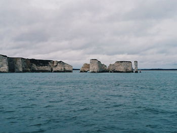 Scenic view of rocks in sea against sky