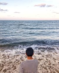 Rear view of boy standing on beach