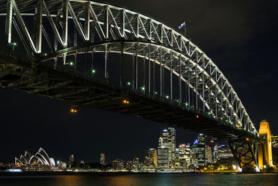 Illuminated bridge over river at night