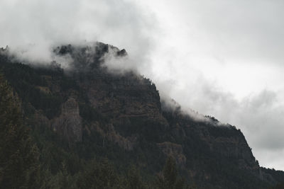 Low angle view of rocky mountains against sky