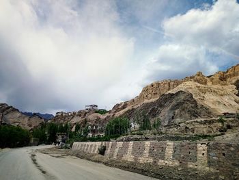 Road by mountains against sky