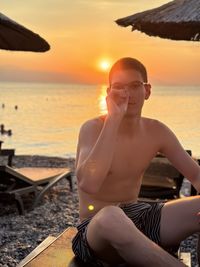 Portrait of young woman sitting at beach