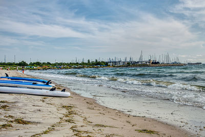 Sailboats moored on beach against sky