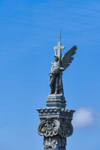 Low angle view of statue against blue sky