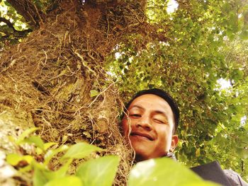 Portrait of smiling young woman against plants