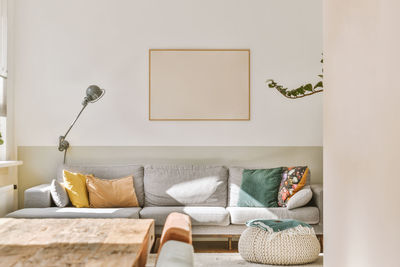 Low section of woman sitting on sofa at home