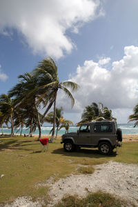 Cars on beach against sky