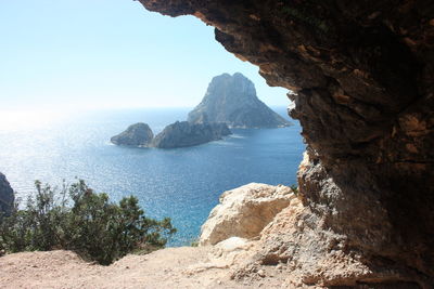 Rock formation on sea shore against sky