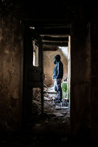 Side view of man standing in abandoned building