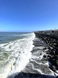 Scenic view of sea against clear blue sky