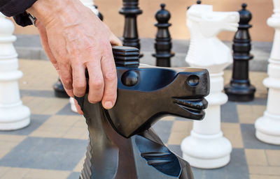 Close-up of man hand on chess board