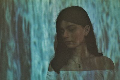 Close-up of thoughtful young woman standing outdoors at night