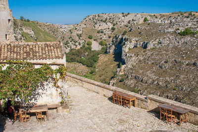 Ancient stone house with grapes tree and old wooden tables 