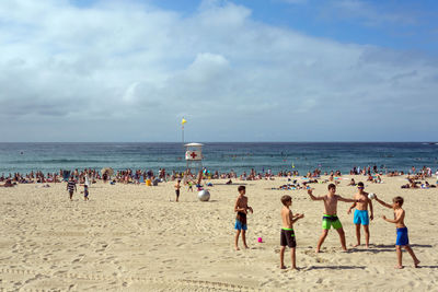 Crowd at beach on sunny day