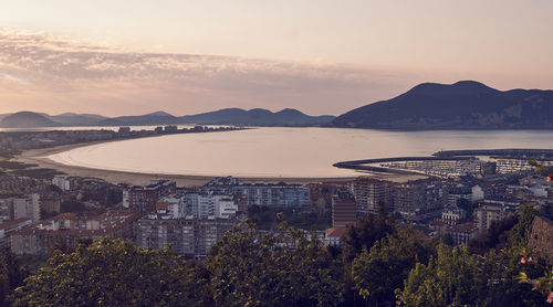 High angle view of townscape by sea against sky