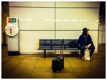 Woman sitting on bench at subway station