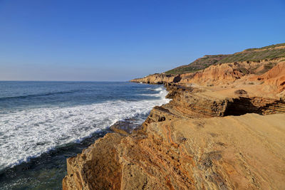 Scenic view of beach against clear blue sky