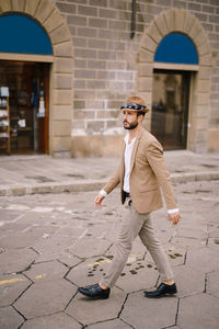 Full length of young man wearing sunglasses on street in city