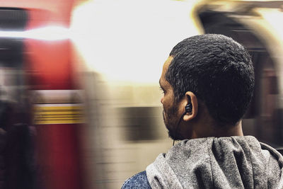 Rear view of man in train at railroad station