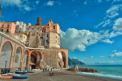 Panoramic view of buildings by sea against sky