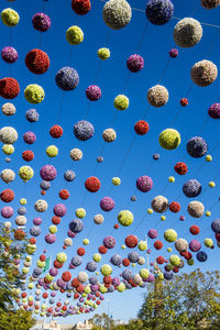 Colorful spherical decorations hanging against clear sky