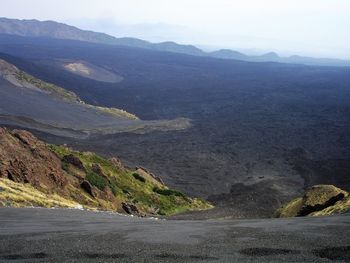 Scenic view of road by mountains against sky