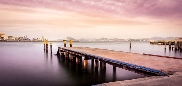 Pier over sea against sky during sunset