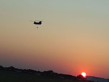 Low angle view of silhouette bird flying against sky during sunset