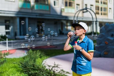 Smiling young woman with bubbles in park