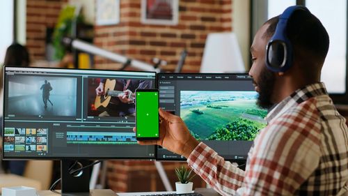Rear view of man using mobile phone in office