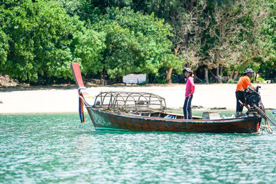 People on boat against trees