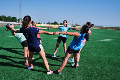 Group of young women practice stretching after their training