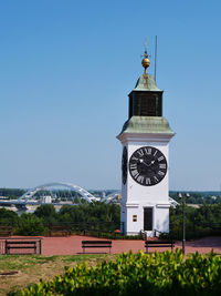 Clock tower amidst buildings against clear sky