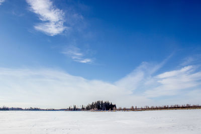 Scenic view of landscape against blue sky during winter