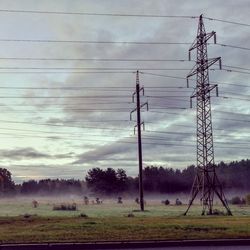 Electricity pylon on field against sky