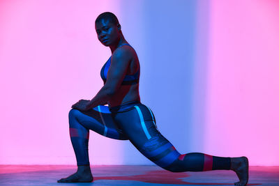 Rear view of shirtless man standing against white background