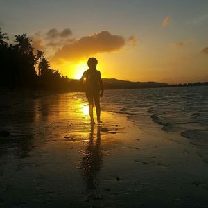 Silhouette of man on water at sunset