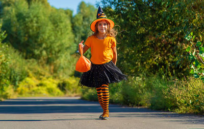 Cute girl wearing halloween costume standing on road
