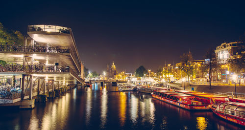 Illuminated bridge over river at night