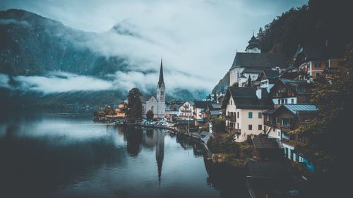 River amidst buildings in city against sky