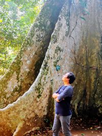 Rear view of man standing on rock in forest