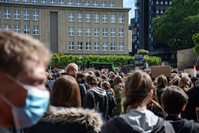 Rear view of people against buildings in city