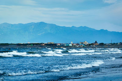 Scenic view of sea and mountains against sky