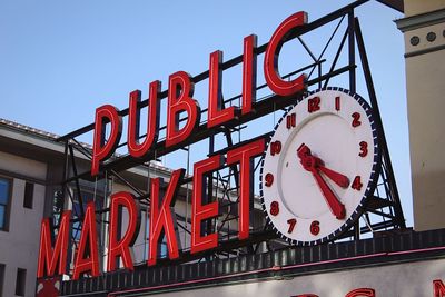 Low angle view of illuminated sign against sky in city