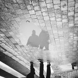 Reflection of people in puddle