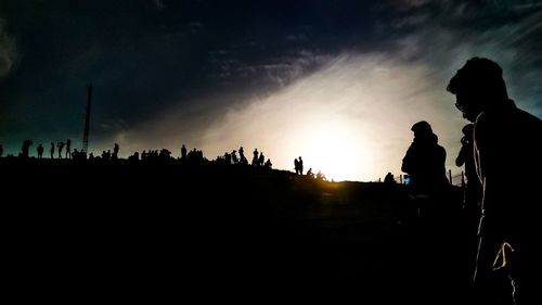 Silhouette people standing against sky during sunset