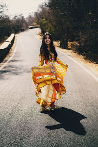 Portrait of young woman walking on road