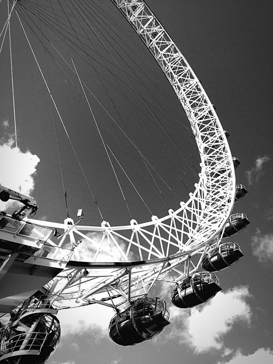 ferris wheel, low angle view, amusement park ride, amusement park, built structure, sky, arts culture and entertainment, architecture, famous place, travel destinations, international landmark, tall - high, connection, tourism, metal, travel, cloud - sky, engineering, outdoors, water