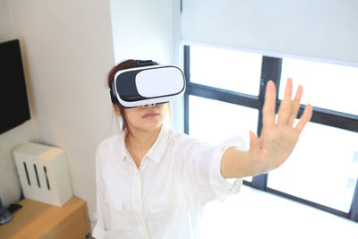 Woman using virtual reality simulator at home