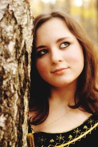 Close-up portrait of young woman with tree